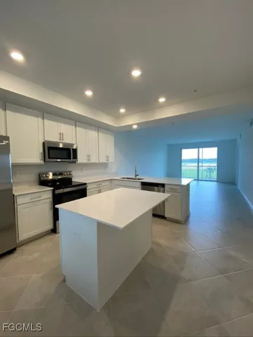 a large kitchen with a large counter top stainless steel appliances and cabinets