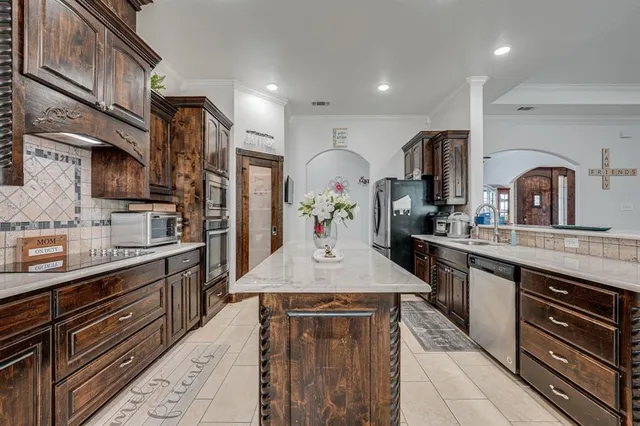 a kitchen with stainless steel appliances granite countertop a sink stove and refrigerator