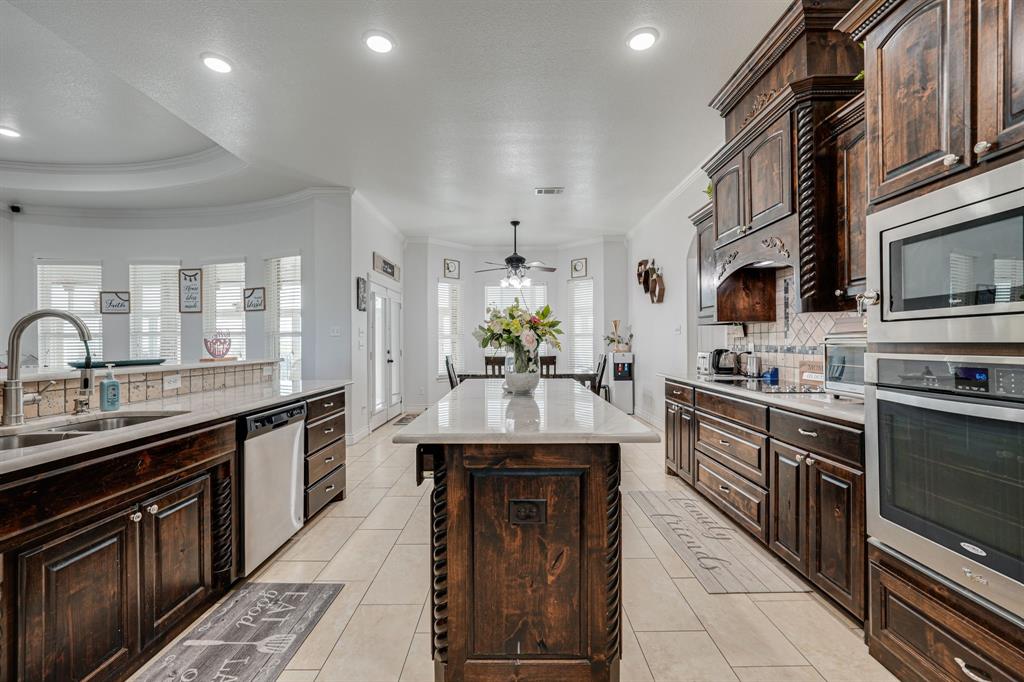 1192 Seaborn Road Ponder, TX 76259 - Photo 16 of 40 a kitchen with stainless steel appliances granite countertop a sink and dishwasher a stove top oven with wooden floor