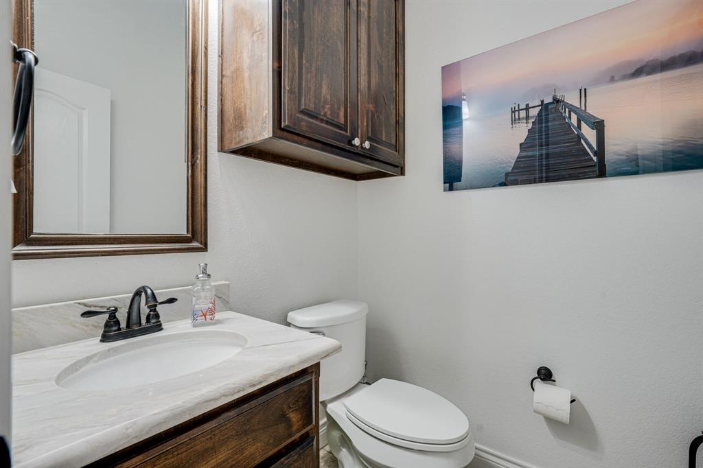 1192 Seaborn Road Ponder, TX 76259 - Photo 28 of 40 a bathroom with a sink a toilet and mirror
