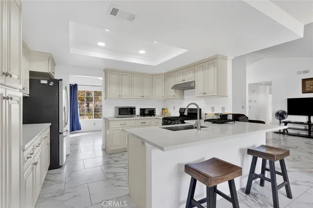 a kitchen with white cabinets and appliances