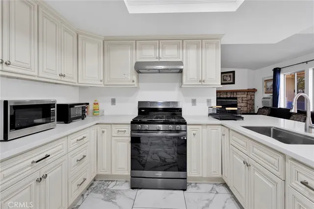 a kitchen with stainless steel appliances granite countertop a stove and a sink
