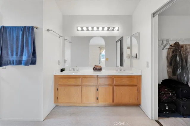 a bathroom with a double vanity sink and mirror with bathtub