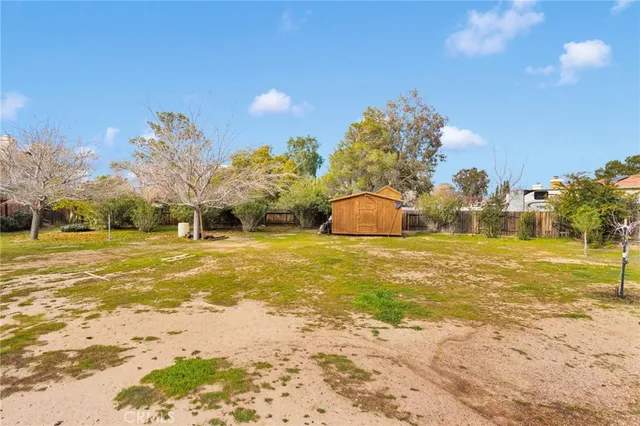 a view of a patio with table and chairs and wooden fence