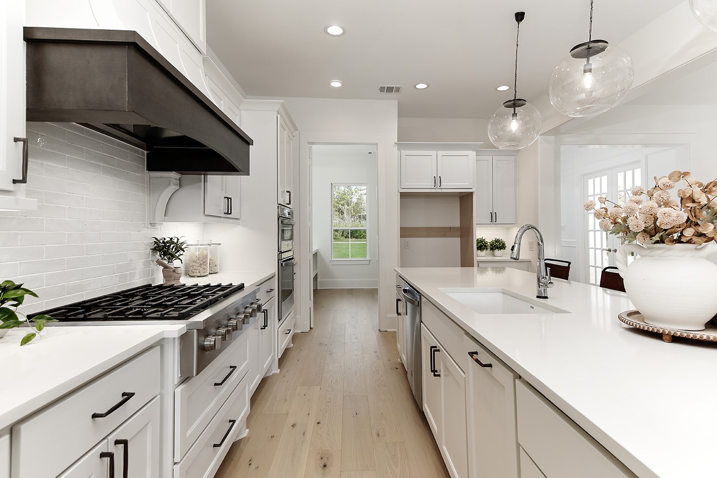 11842 Grand N Road Willis, TX 77378 - Photo 13 of 38 High end finishes such as quartz counters, tile backsplash, and white oak wood flooring add warmth and sophistication.