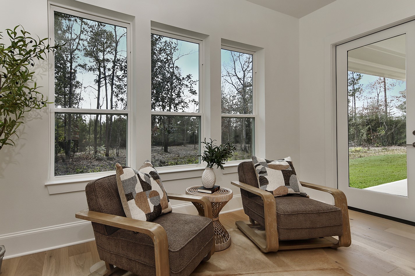 11842 Grand N Road Willis, TX 77378 - Photo 21 of 38 Cozy sitting area in the primary suite has beautiful views of surrounding trees and private access to covered patio.