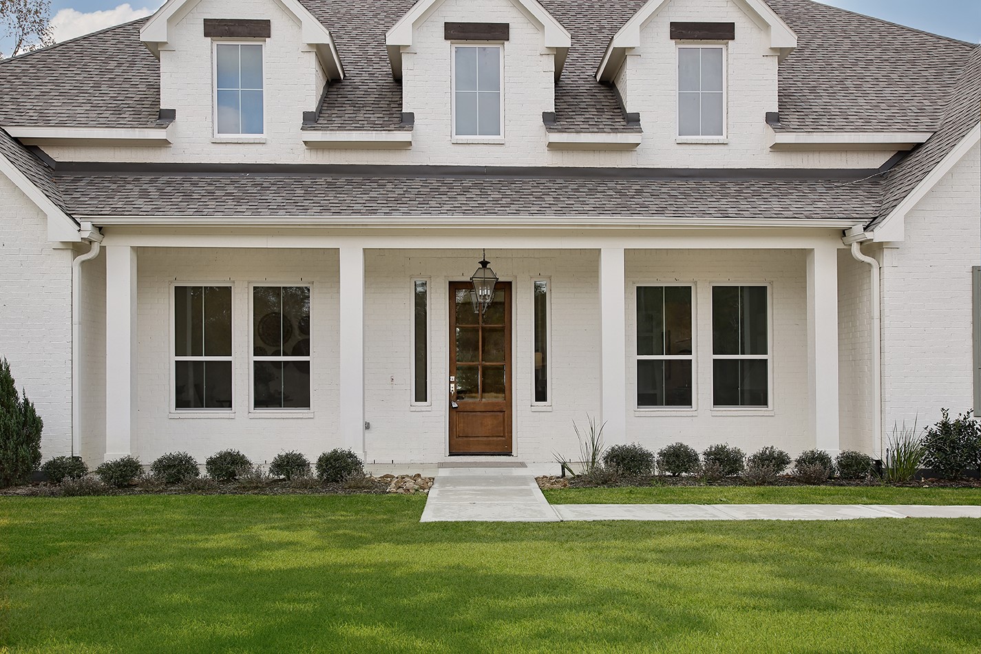 11842 Grand N Road Willis, TX 77378 - Photo 3 of 38 Exceptional all brick beauty has a familiar, warm and welcoming atmosphere with front porch, charming wooden door and iron lantern.