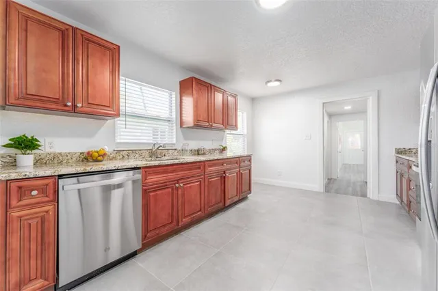 a kitchen with stainless steel appliances granite countertop a refrigerator and a sink