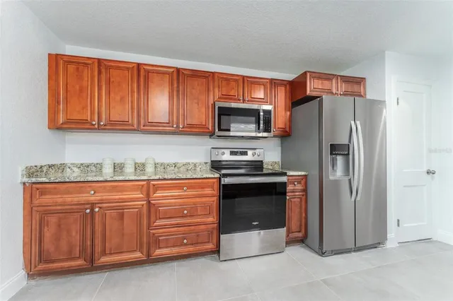 a kitchen with stainless steel appliances granite countertop a refrigerator stove and oven