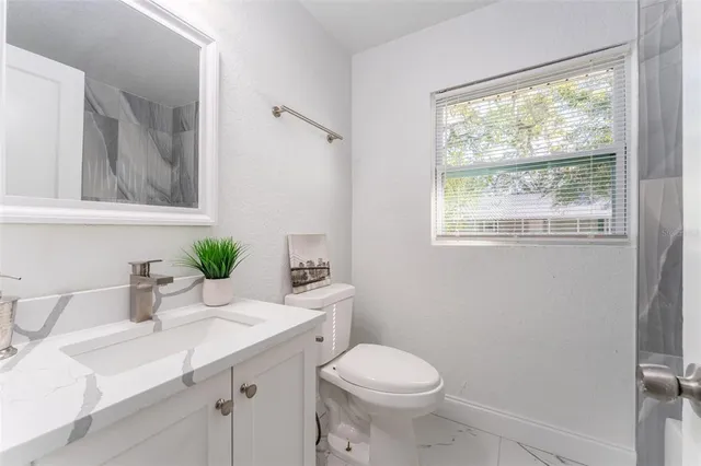 a bathroom with a sink toilet and window