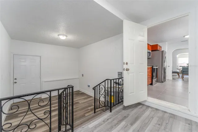 wooden floor with an entryway and chandelier