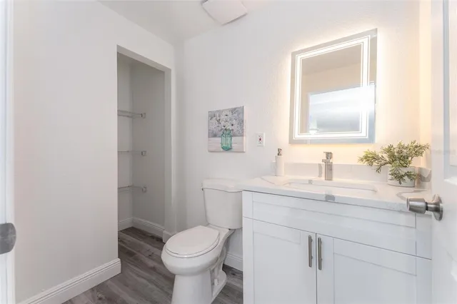 a bathroom with a granite countertop toilet sink and mirror