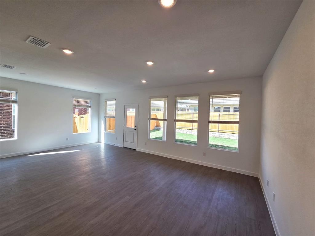 925 Calley Pear Trail Princeton, TX 75407 - Photo 12 of 24 an empty room with wooden floor and windows