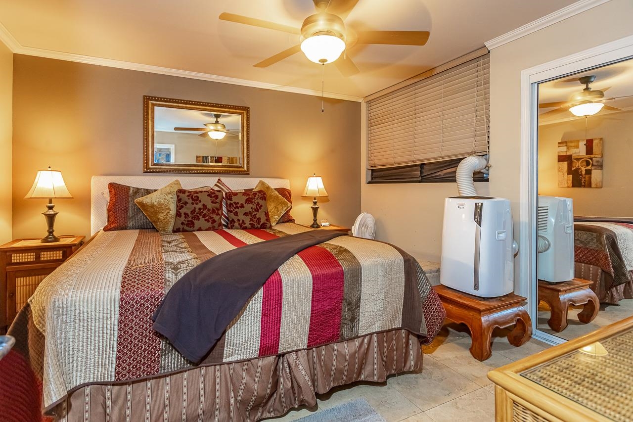 2381 South Kihei Road, Unit B107 Kihei, HI 96753 - Photo 11 of 29 a bedroom with bed and a chandelier