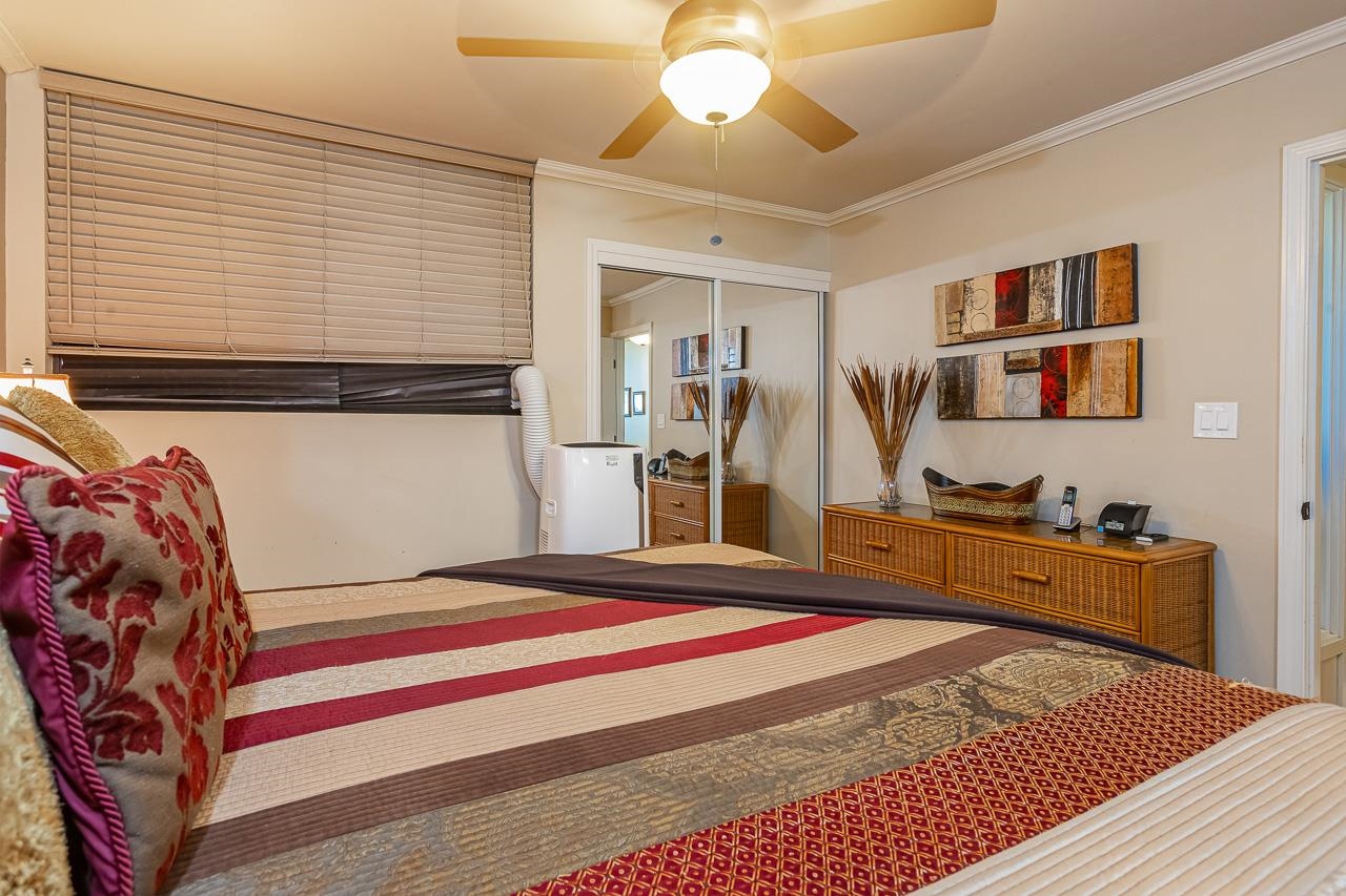 2381 South Kihei Road, Unit B107 Kihei, HI 96753 - Photo 13 of 29 a bedroom with a bed and a chandelier