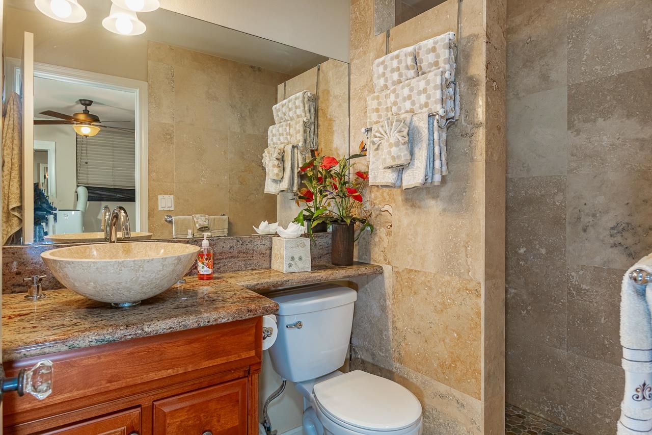 2381 South Kihei Road, Unit B107 Kihei, HI 96753 - Photo 14 of 29 a view of a bathroom with a granite countertop toilet a sink and a mirror