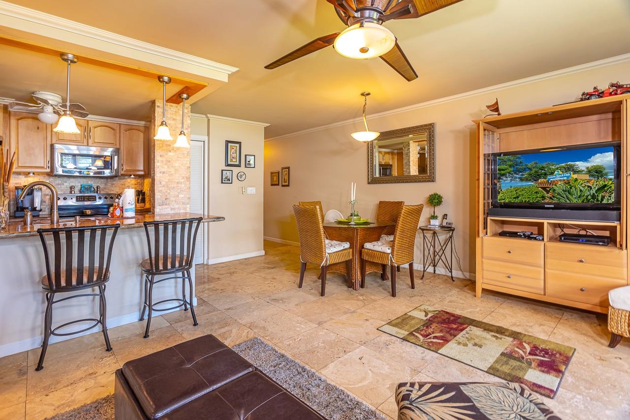 2381 South Kihei Road, Unit B107 Kihei, HI 96753 - Photo 3 of 29 a dining room with furniture a rug and a floor to ceiling window