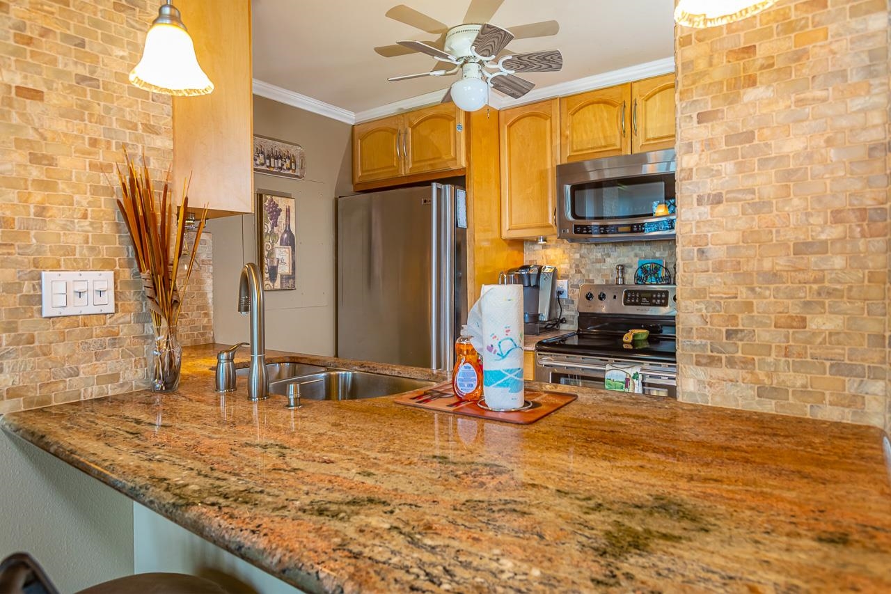 2381 South Kihei Road, Unit B107 Kihei, HI 96753 - Photo 8 of 29 a kitchen with kitchen island granite countertop a sink appliances and cabinets