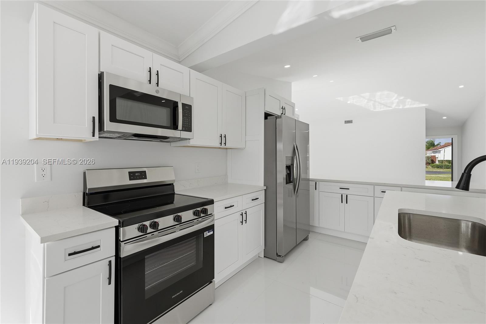 15956 Southwest 83rd Terrace Miami, FL 33193 - Photo 6 of 44 a kitchen with stainless steel appliances a stove microwave and refrigerator