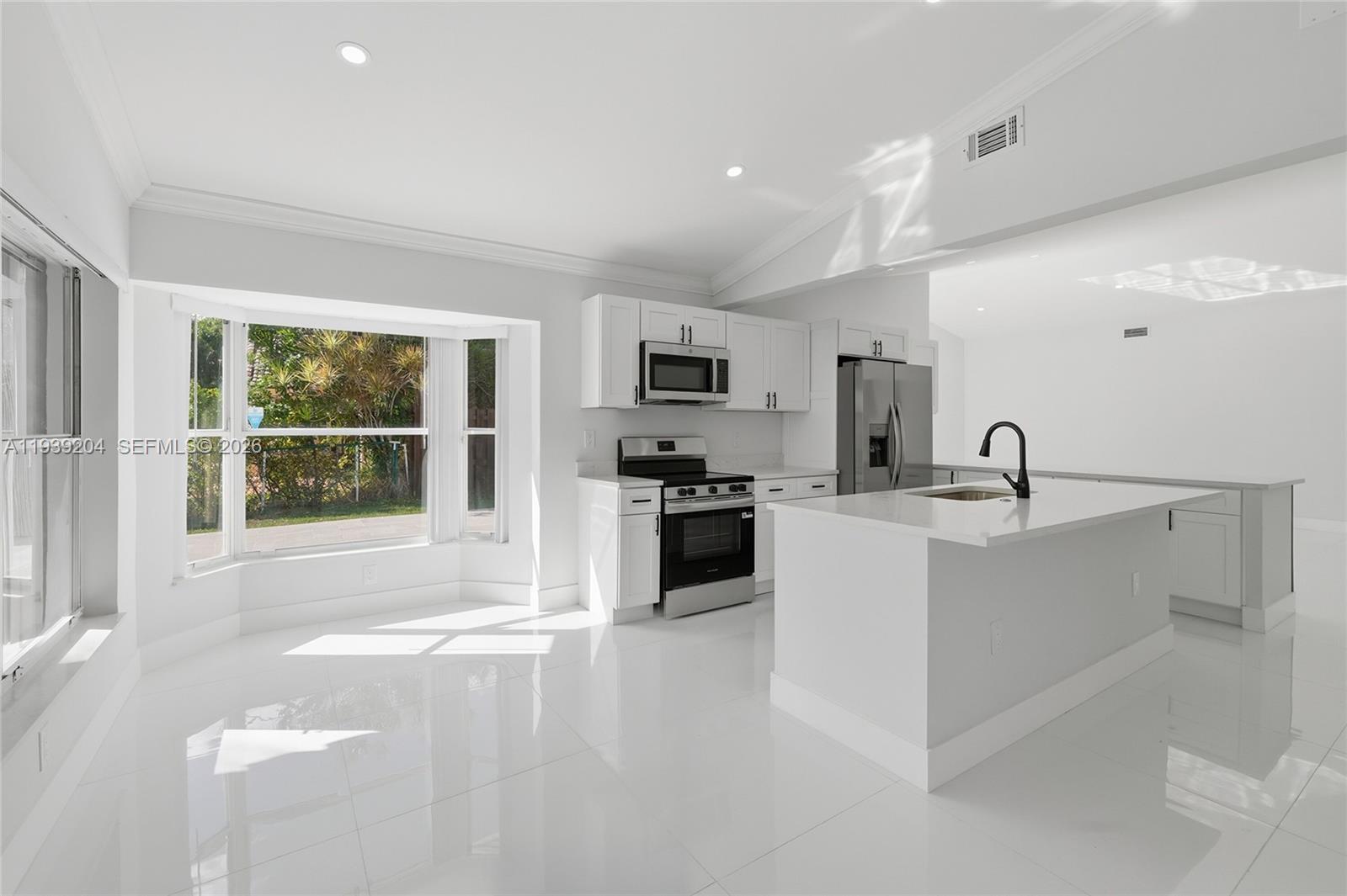 15956 Southwest 83rd Terrace Miami, FL 33193 - Photo 8 of 44 a large kitchen with a stove a sink and a microwave