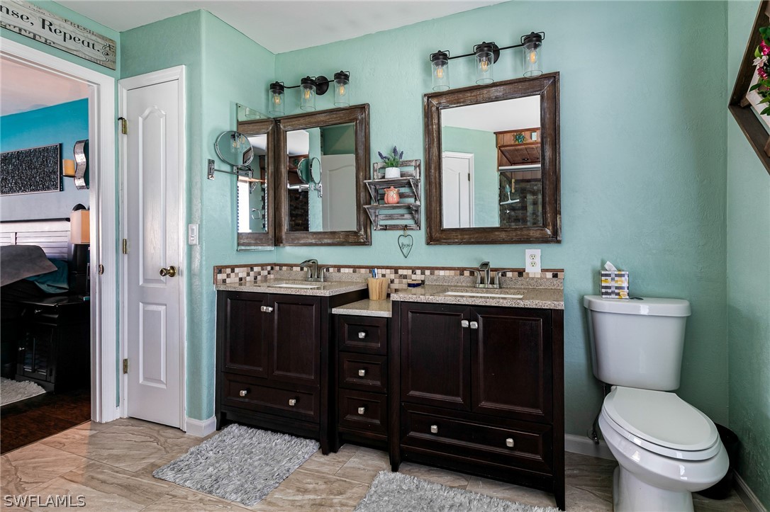 17557 Ingram Road Fort Myers, FL 33967 - Photo 16 of 29 a bathroom with a toilet a sink and mirror