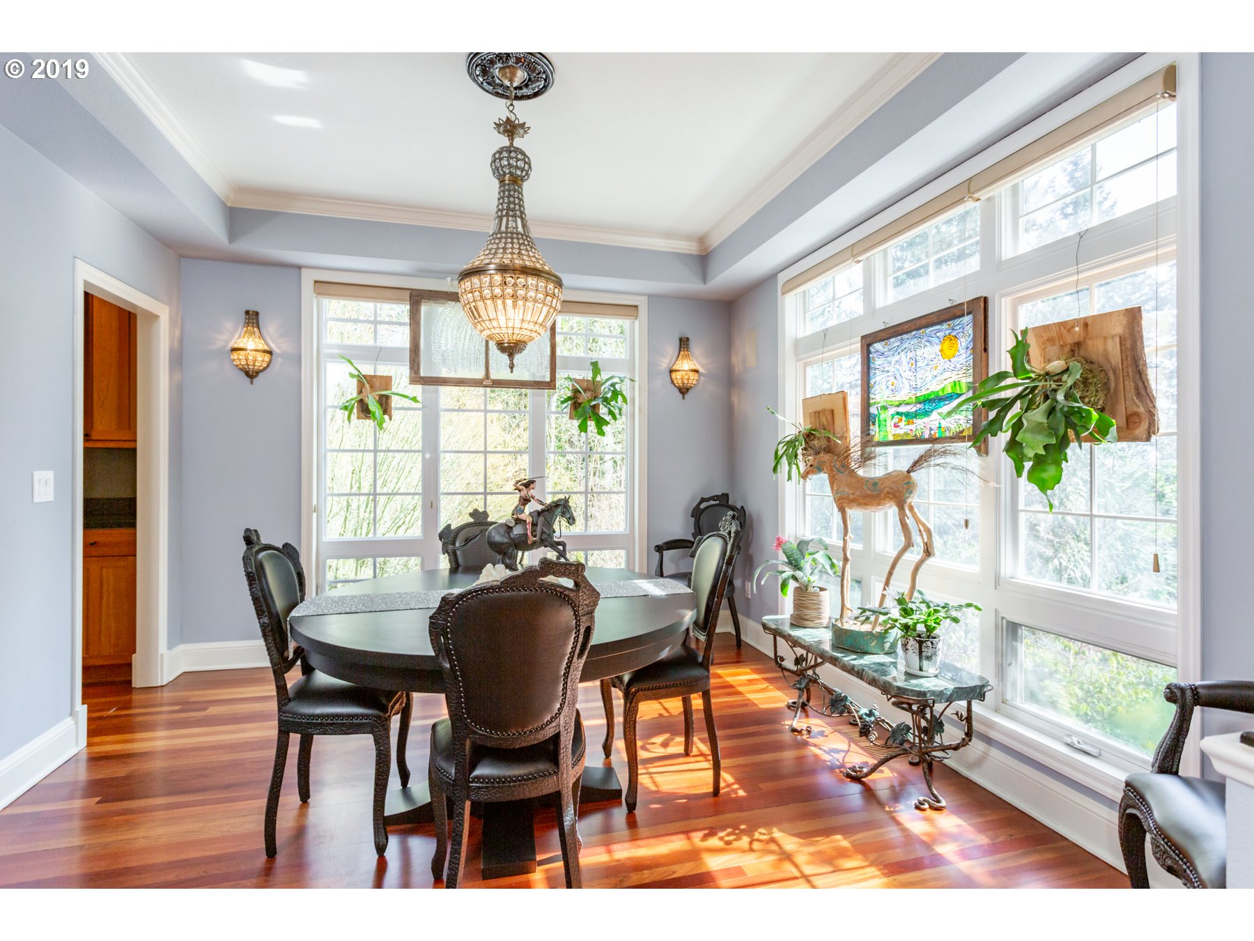 731 Southwest Bancroft Terrace Portland, OR 97239 - Photo 9 of 46 a dining room with wooden floor a chandelier a glass table and chairs