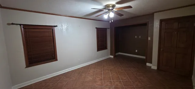 a view of an empty room with a ceiling fan