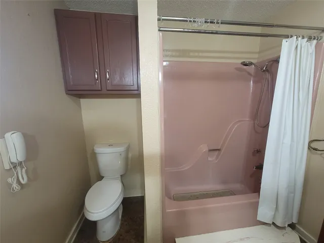 a bathroom with a toilet and a shower