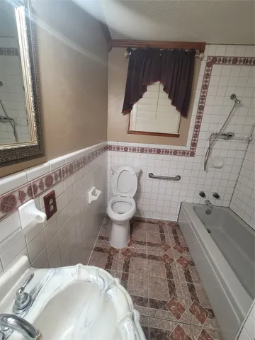 a bathroom with a sink a toilet and bathtub
