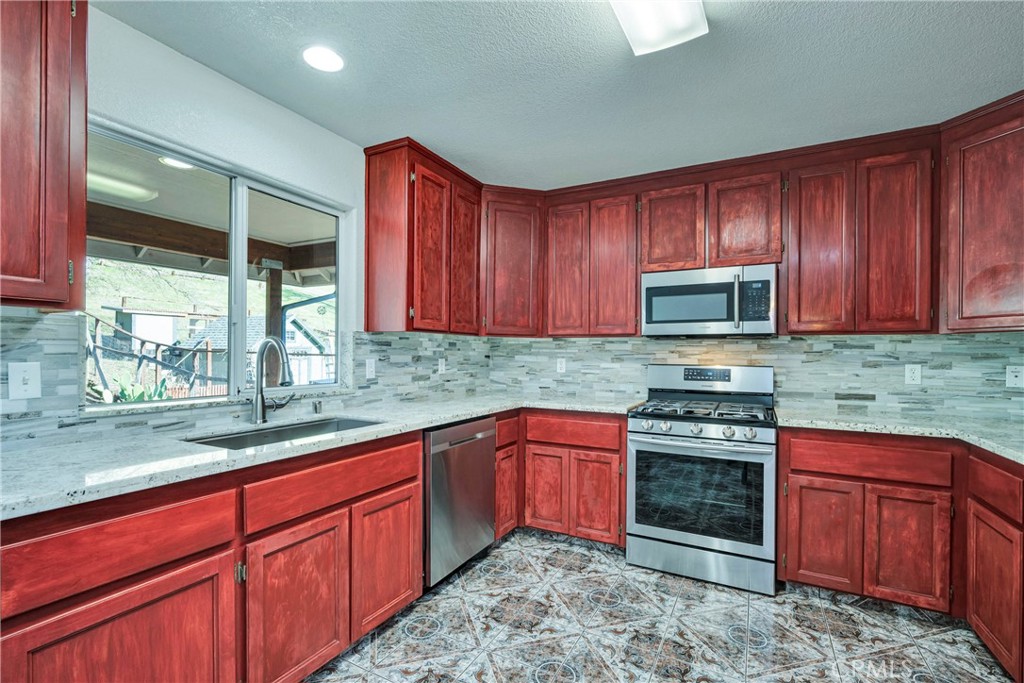 18230 Hidden Valley Road Hidden Valley Lake, CA 95467 - Photo 9 of 22 a kitchen with stainless steel appliances granite countertop wooden cabinets a stove top oven a sink and dishwasher