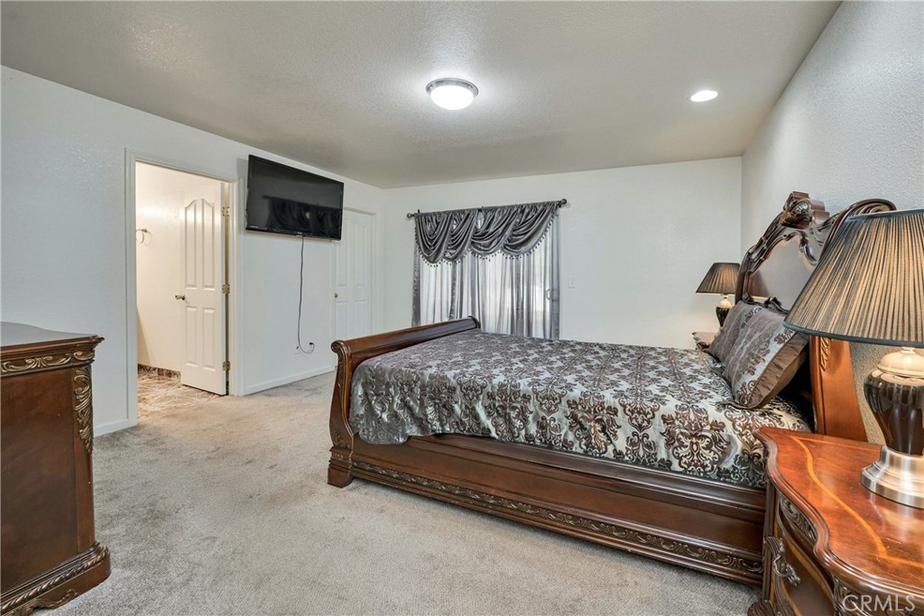 18230 Hidden Valley Road Hidden Valley Lake, CA 95467 - Photo 10 of 22 a bedroom with a bed and a flat tv screen on wall