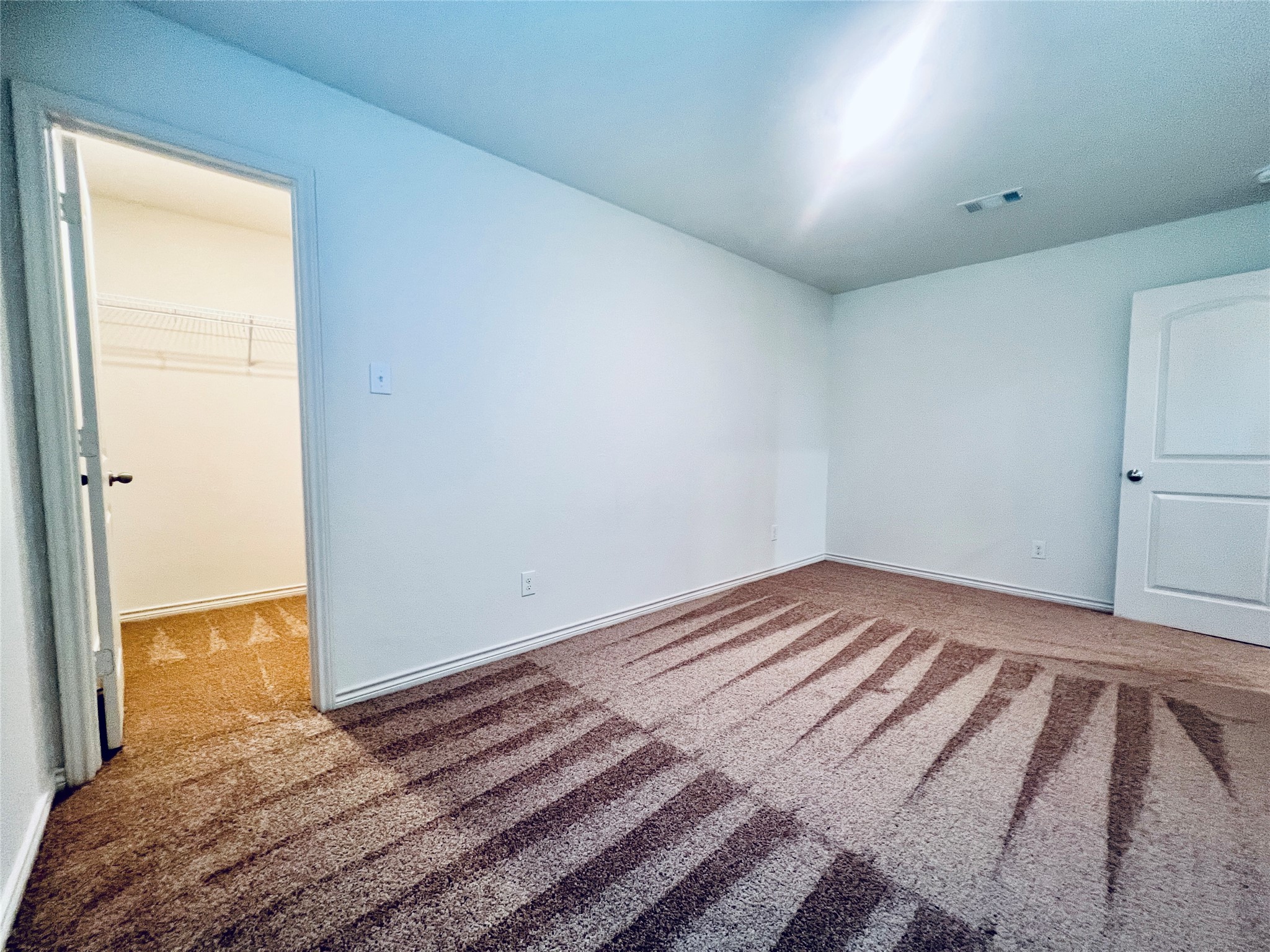 520 Locksley Cove Jarrell, TX 76537 - Photo 23 of 27 A spacious chamber with soft carpeting, featuring a convenient walk-in closet for ample storage.