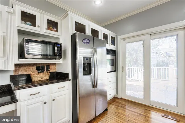 a kitchen with stainless steel appliances granite countertop a refrigerator and a stove top oven