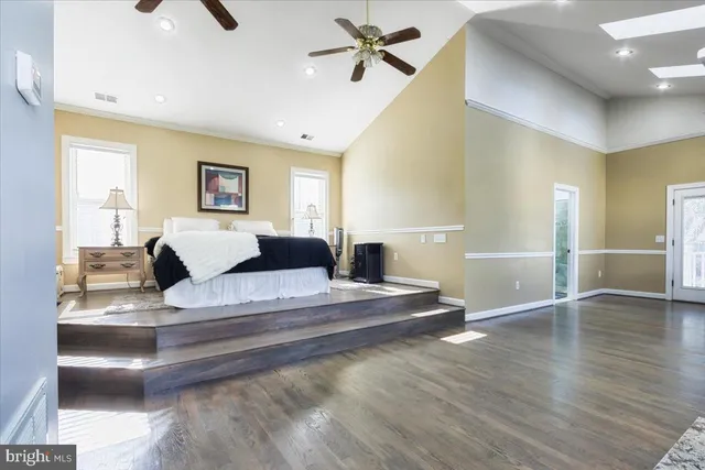 a spacious bedroom with a bed and wooden floor