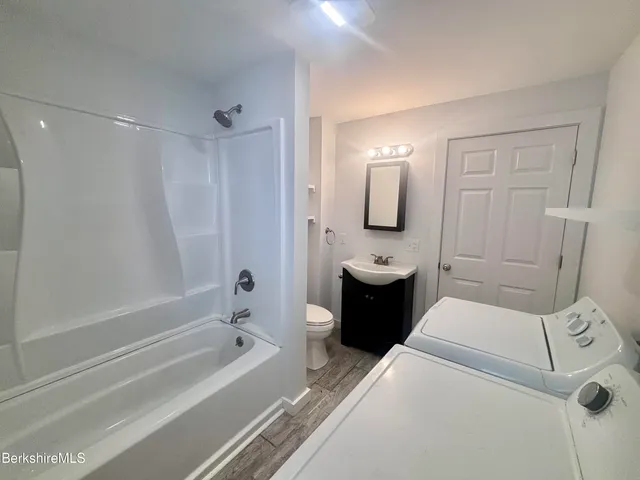 a bathroom with a sink a toilet and shower