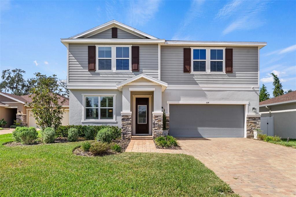 a front view of a house with a yard and garage