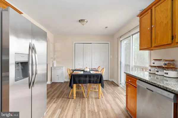 a kitchen with a table chairs refrigerator and window