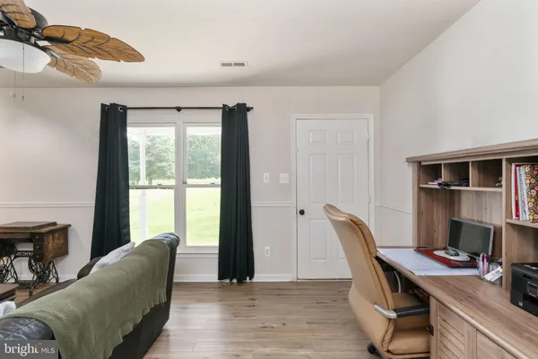 a view of a workspace with furniture and a window