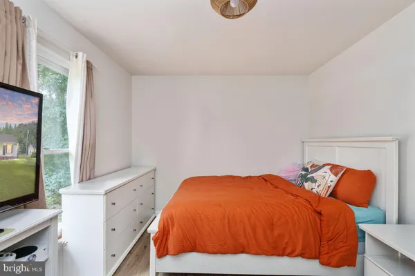 a bedroom with a bed and a flat tv screen on the dresser