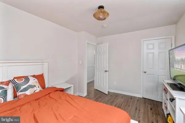 a bedroom with a bed and a flat tv screen on dresser