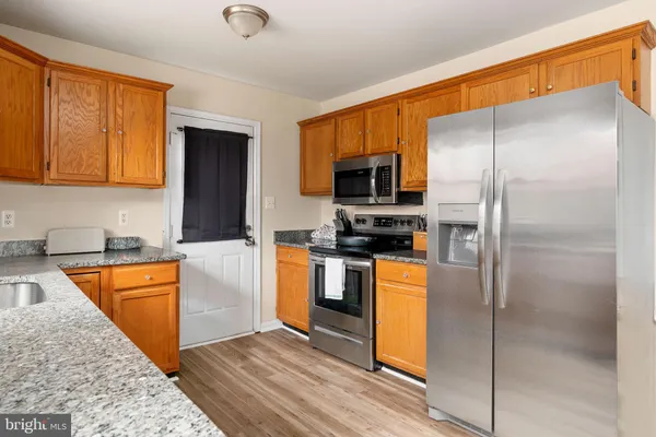 a kitchen with stainless steel appliances granite countertop a refrigerator a stove top oven a sink and dishwasher