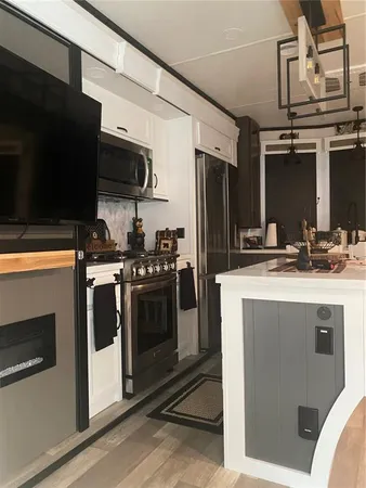 a kitchen with stainless steel appliances kitchen island granite countertop a stove a sink and a microwave