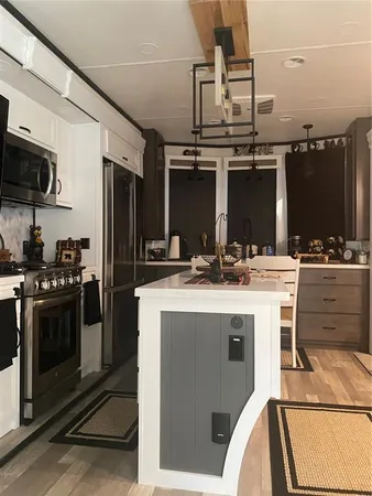 a kitchen with kitchen island stainless steel appliances a sink stove and refrigerator