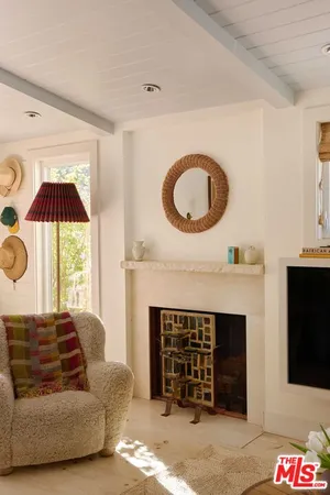 a living room with furniture a fireplace and a large window