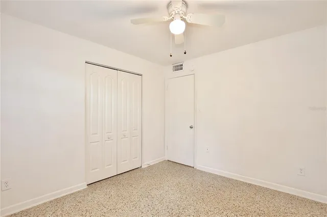 an empty room with a chandelier fan