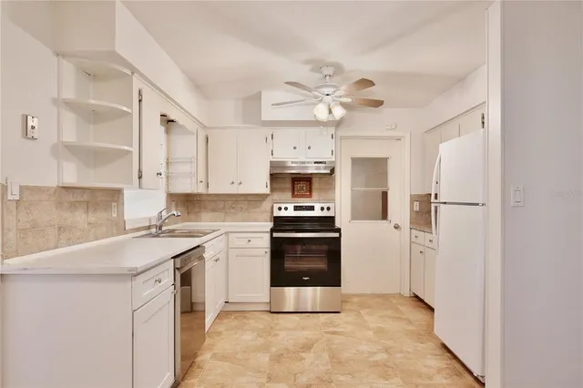a kitchen with cabinets stainless steel appliances and a counter space