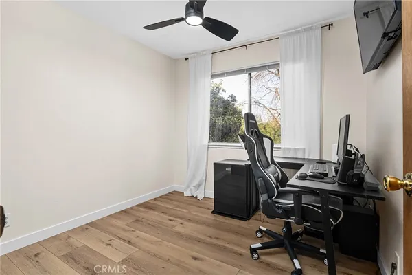a view of workspace with wooden floor windows ceiling fan and windows