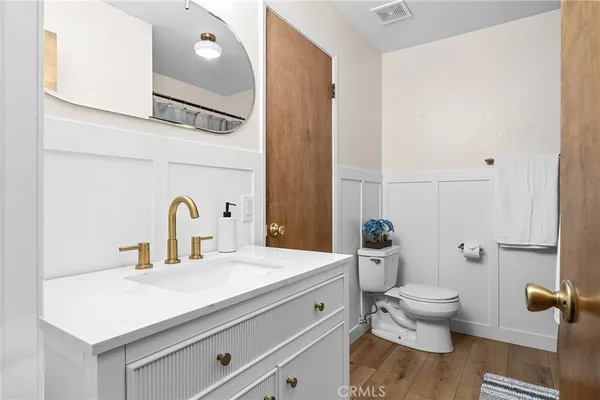 a bathroom with a granite countertop toilet sink and mirror