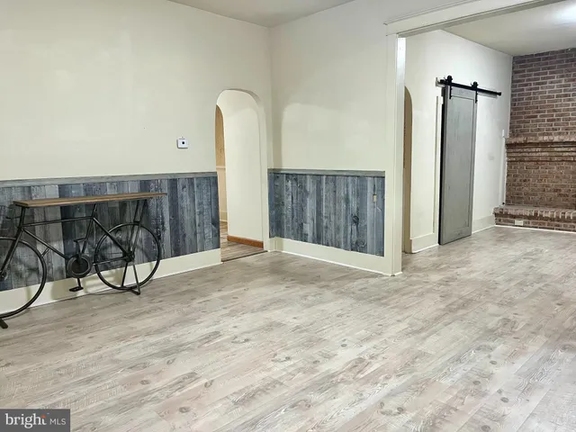 a view of a living room with furniture and wooden floor