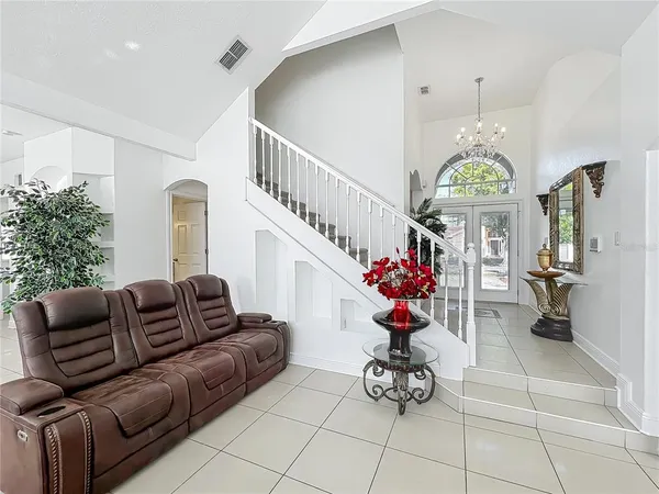 a living room with furniture flowers and a chandelier